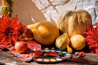 Sonbahar renkli estetik yaşam: sarı meyveler, sebzeler ve fırçalı parlak boyalar, balkabağı, armut, elma ve kavun. Şükran Günü. Sonbahar, kızıl georgine ile sakin bir hayat, modern gölgeler..