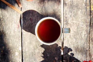 Bir fincan çay, ahşap arka planda, modaya uygun doğal gölgelerle kırsal tarzda. Üst Manzara. Sonbahar sıcacık estetik natürmort. Sıcak mevsim. Hint Yazı