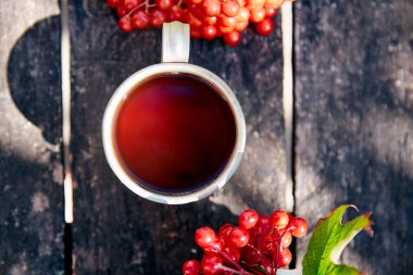 Doğal sağlıklı organik çay ve taze viburnum meyveleri. Sonbahar estetiği. Yüksek kalite fotoğraf
