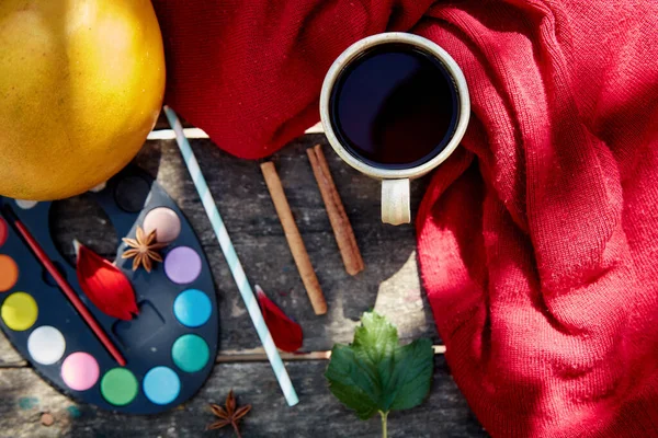 Autumn aesthetic still life: fruits, vegetables and bright paints with a cinnamon sticks, viburnum, flower petals and cup of tea. Thanksgiving Day concept. Autumn flat lay with cozy modern shadows.
