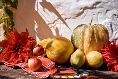 Sonbahar estetik fuarı: sarı meyve ve sebzeler, fırçalı parlak boyalar, balkabağı, armut, elma ve kavun. Şükran Günü konsepti. Kırmızı Georgine 'li dekorasyonlar, modern gölgeler, kopyalama alanı. Yüksek kalite fotoğraf