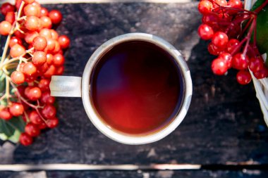 Doğal sağlıklı organik çay ve taze viburnum meyveleri. Sonbahar estetiği