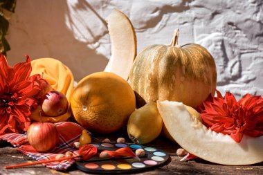 Sonbahar modern gölgeli yaşam: sarı sebzeler, meyveler ve fırçalı parlak boyalar, balkabağı, armut, elma ve kavun. Şükran Günü konsepti. Sonbahar kırmızı Gürcistan dekorasyonu