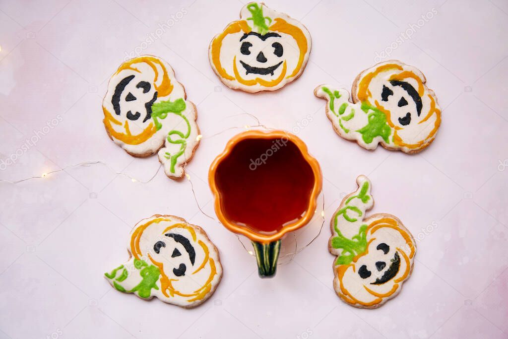 Cup of tea and Halloween homemade cookies top view. Creative trick or treat concept. Atmospheric autumn table decorations. Home cooking and coziness