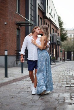 Şık bir adam ve güzel bir kadın şehirde dans ediyor. Çiftler tutkulu öpüşürler. Beyaz tişörtlü ve şortlu erkek arkadaş, uzun etekli kız arkadaş. İki Kişinin Tam Uzunluğu