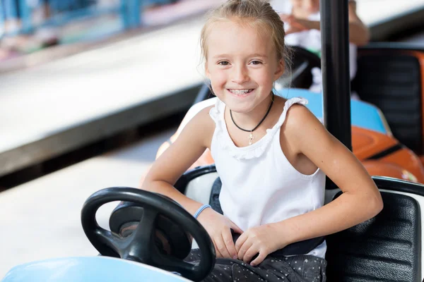 Счастливый ребенок ездит на электромобиле по парку — стоковое фото
