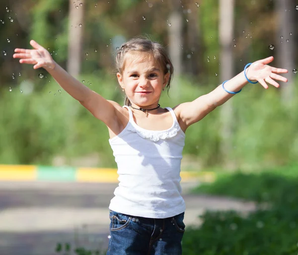 Chica salpicando agua en el parque — Foto de Stock