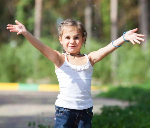 Meisje spatten van water in het park — Stockfoto