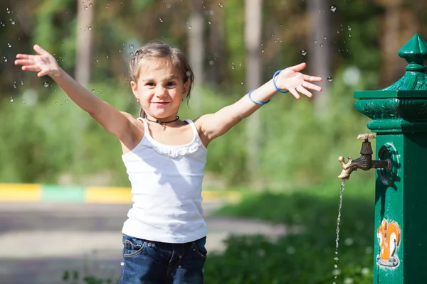 Dívka, stříkající vodě v parku — Stock fotografie