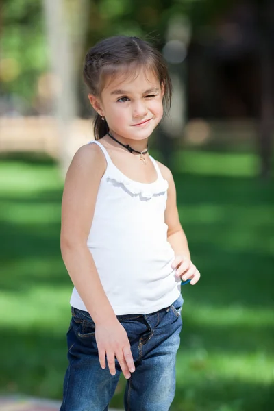 Happy girl standing on the lawn in the park — Stock Photo, Image