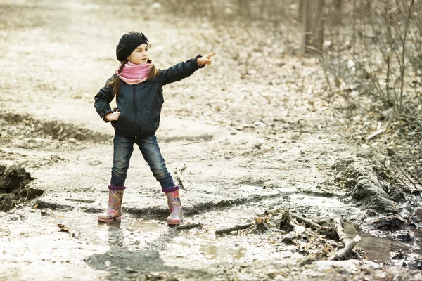 Ung flicka i gummistövlar i skogen höst — Stockfoto