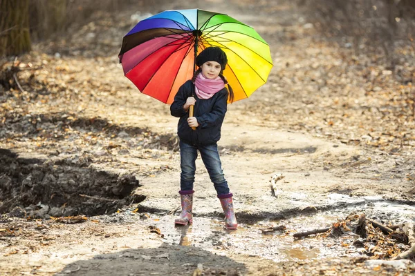 Mädchen mit buntem Regenschirm im Herbstpark — Stockfoto