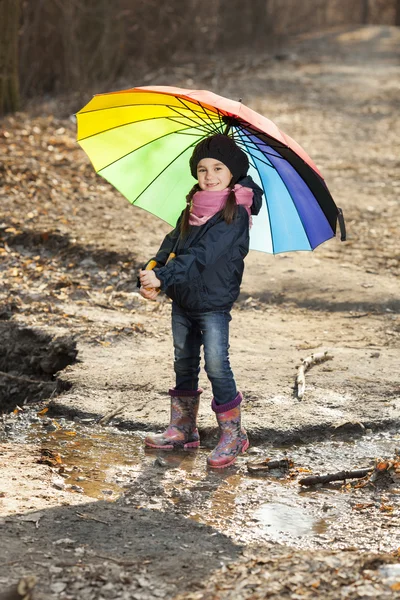 Mädchen mit buntem Regenschirm im Herbstpark — Stockfoto