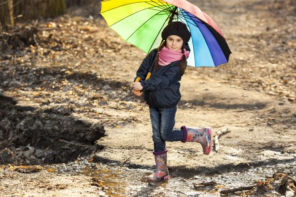 Mädchen mit buntem Regenschirm im Herbstpark — Stockfoto