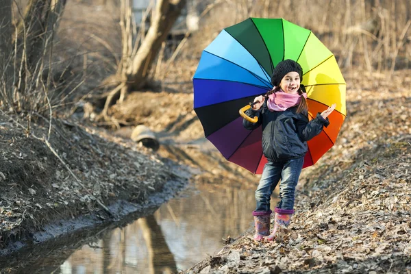 Meisje met veelkleurige paraplu in herfst park — Stockfoto