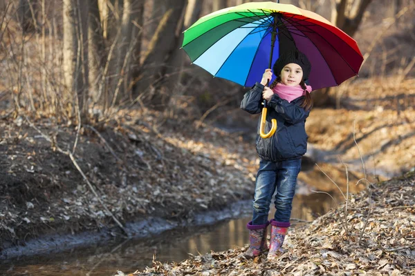 Mädchen mit buntem Regenschirm im Herbstpark — Stockfoto