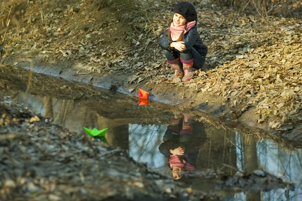 Chica en la orilla del río juega Paper Boat — Foto de Stock