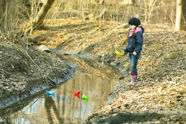 Chica en la orilla del río juega Paper Boat — Foto de Stock