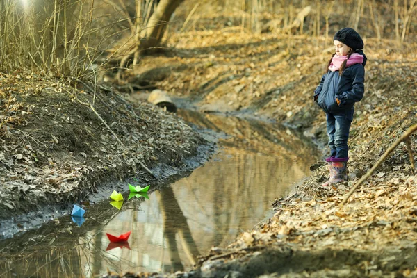 Girl on the river bank plays Paper Boat — Stock Photo, Image