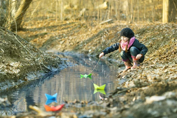 Ragazza sulla riva del fiume gioca Paper Boat — Foto Stock