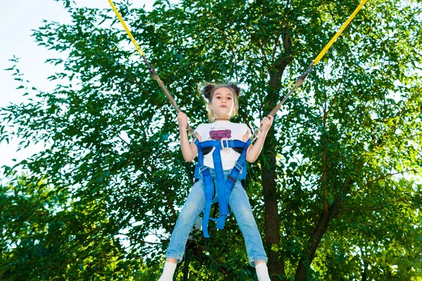 Flicka hoppar på en studsmatta — Stockfoto