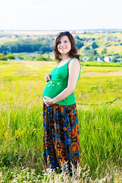 Retrato de uma bela mulher grávida no campo — Fotografia de Stock