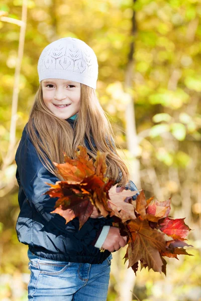 Szép lány egy csomó levelek — Stock Fotó