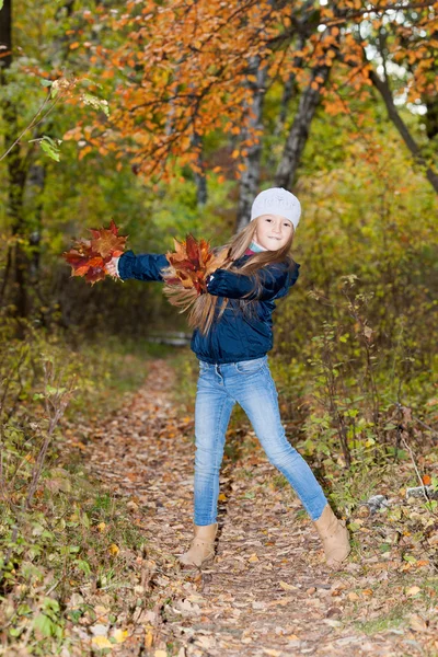 Linda menina com um monte de folhas — Fotografia de Stock