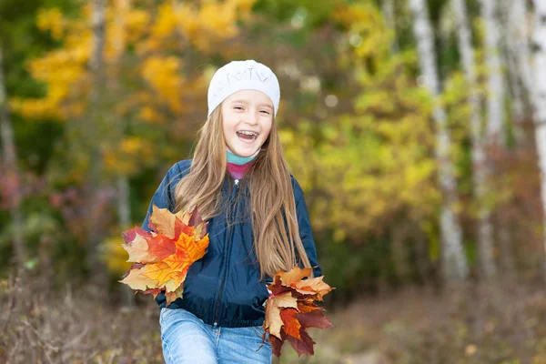 Belle fille avec un tas de feuilles — Photo