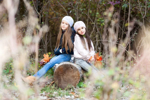 Günlük poz üzerinde oturan bir bere takan iki güzel kız — Stok fotoğraf