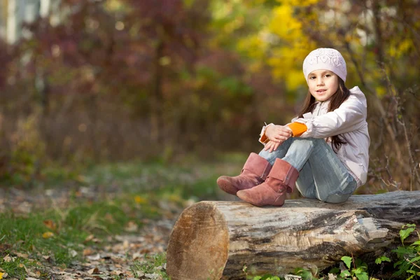 Lány ül a napló az erdőben — Stock Fotó