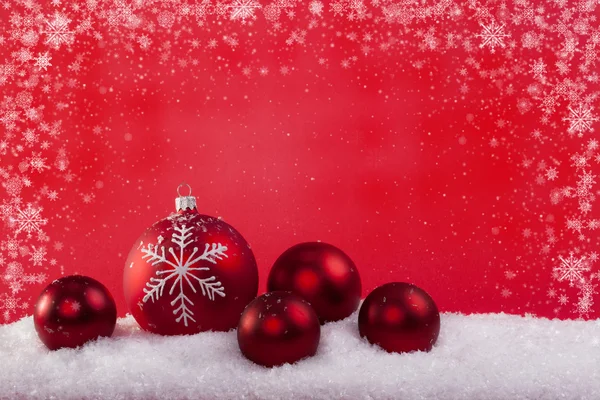Червоні різдвяні кульки на снігу — стокове фото