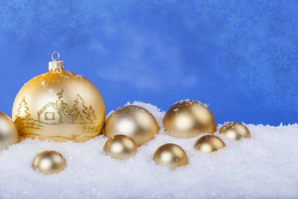 Золоті різдвяні кульки на снігу — стокове фото