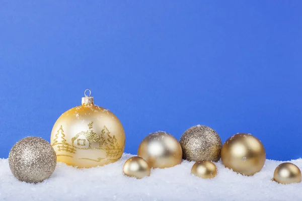 Золоті різдвяні кульки на снігу — стокове фото