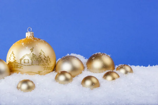 Goldene Weihnachtskugeln im Schnee — Stockfoto