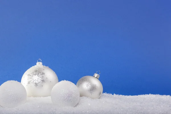 Witte kerstballen in de sneeuw — Stockfoto