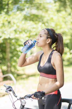 Su şişesi bisiklet ile dışarı egzersiz sonra ile atletik kadın
