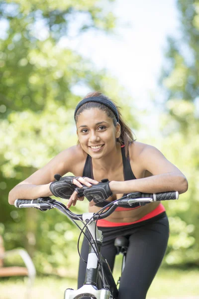 Porträtt av vackra leende latin athletic kvinna med cykel, ou — Stockfoto
