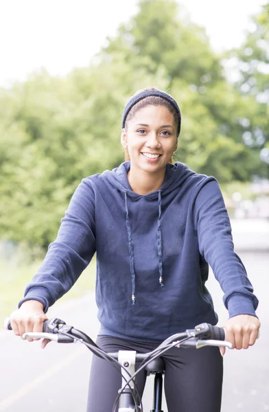 Porträtt av leende vackra kvinna tränar med cykel, utomhus. — Stockfoto