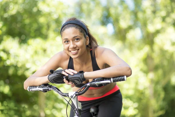 Porträtt av vackra leende latin athletic kvinna med cykel, ou — Stockfoto