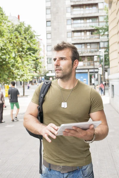 Homem casual com computador tablet na rua olhando para longe, conceito de vida moderna . — Fotografia de Stock