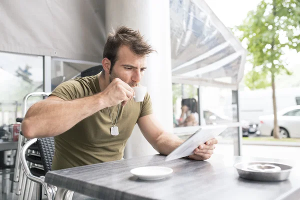 Homem bebendo café e computador portátil tablet no restaurante terraço . — Fotografia de Stock