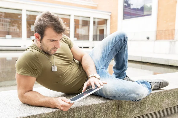 Man koppla av och vila liggande i parken och bärbar dator tablet PC, moderna livsstilskoncept. — Stockfoto