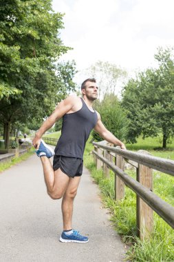 Yapan atletik güçlü erkek açık egzersiz öncesine uzanır.
