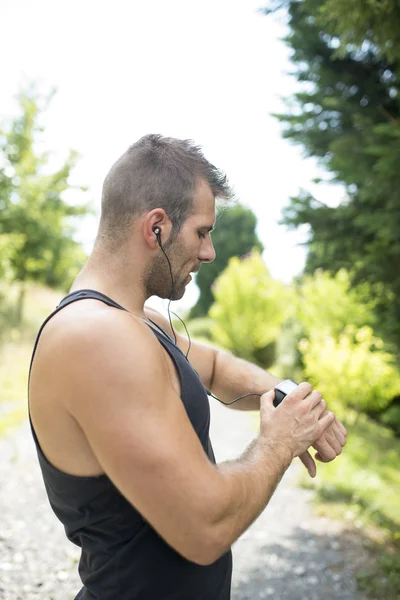 Portrait d'un homme athlétique écoutant de la musique avant l'exercice, sorti — Photo