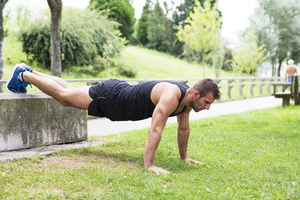 Athletic stark man gör armhävningar, utomhus. — Stockfoto