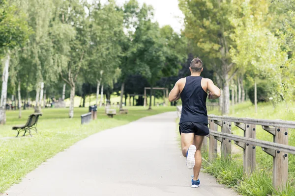 Atletisk man kör och tränar i parken, hälsosam livsstilskoncept. — Stockfoto