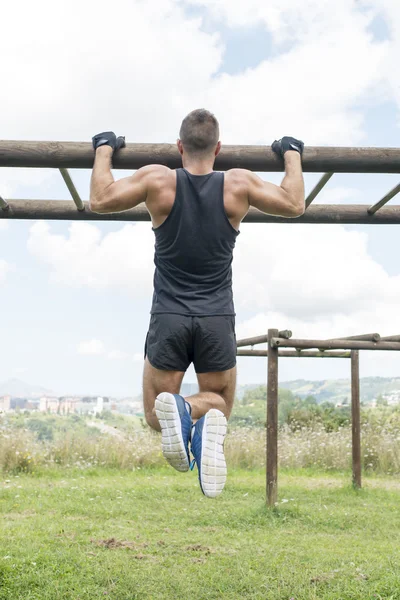 Sportovní svalnatý muž kliky, venkovní. — Stock fotografie