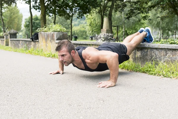 Muž, výcvik a cvičení dělá push up v parku. — Stock fotografie