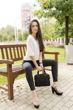 Sokakta bankta oturan zarif güzel kadın.
